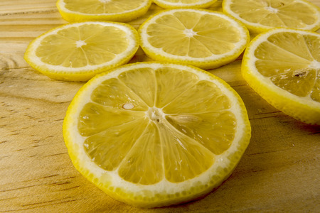 Fresh lemon slices on the wooden background.の写真素材