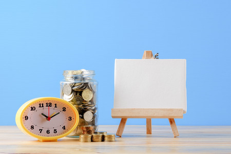Mason jar with coins over blue back drop. Saving concept.