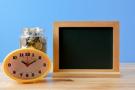 Mason jar with coins over blue back drop. Saving concept.の写真素材