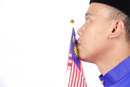 Asian young man with Malaysia flag for National Day celebration.