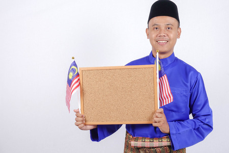Asian young man with Malaysia flag for National Day celebration.