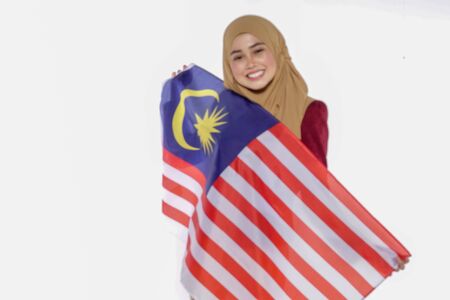 Young beutiful lady holds Malaysia flag isoleted on whitebackground.の写真素材