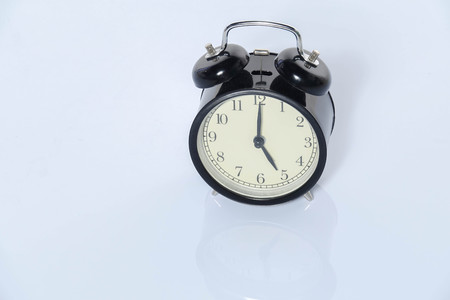 Black alarm clock isolated on white.