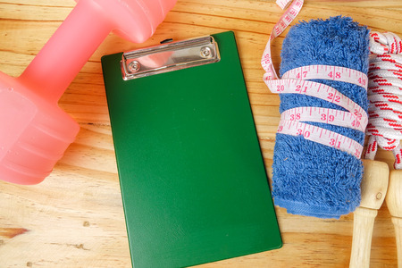 Dumbell and skipping rope on wooden background. Fitness and healthy life concept.の写真素材