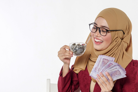 Beautiful lady happily  holding and showing money isolated on a white backgroundの写真素材