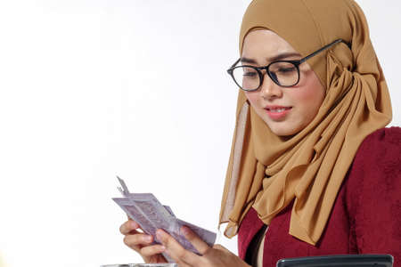 Beautiful lady happily  holding and showing money isolated on a white backgroundの写真素材