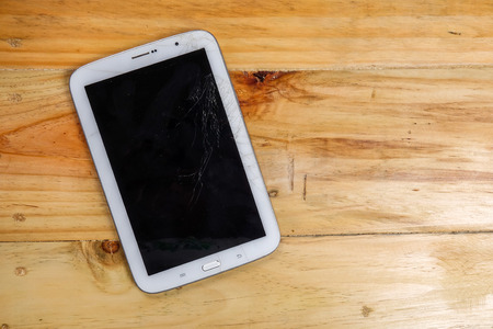 Cracked LCD screen of tablet on rustic table.の写真素材
