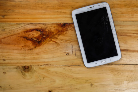 Cracked LCD screen of tablet on rustic table.の写真素材