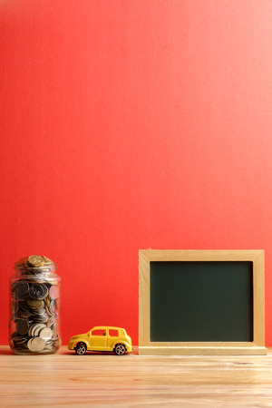 Saving for car concept with coins in the jar and miniature car.の写真素材