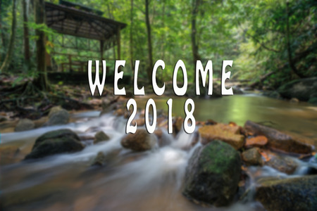 WELCOME 2018 text with the blurred landscape during sunset.の写真素材