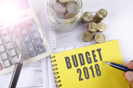 Magnify glass and coins on keyboard with BUDGET 2018. Business concept.の写真素材