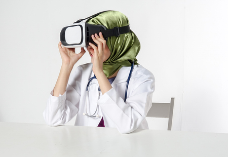 Female doctor wearing virtual reality glasses isolated on white backgroundの写真素材
