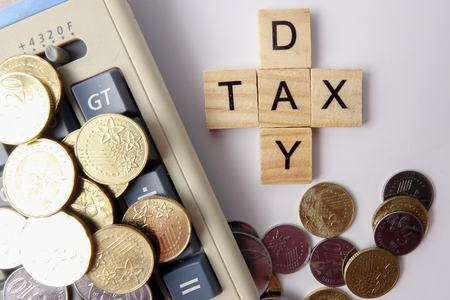 TAX DAY CONCEPT: Wooden letter of TAX DAY arranged with coins on white background.の写真素材