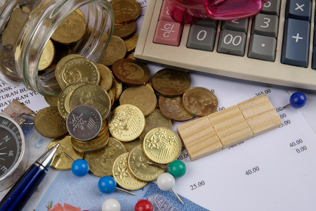 TAX CONCEPT. Coins,calculator,bank notes and wood plate on a white table.の写真素材