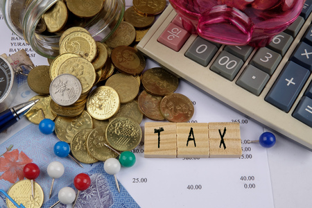TAX CONCEPT. Coins,calculator,bank notes and wood plate on a white table.の写真素材