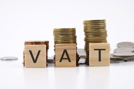 VAT Value Added Tax on Stacked Coins with White Backgroundの写真素材