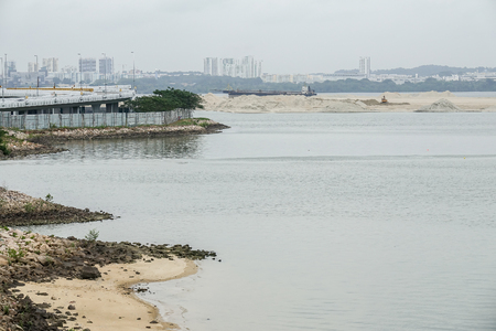 Dredging panning sand on the beach during the construction of a new sea freight terminal in the harbor of port.の写真素材