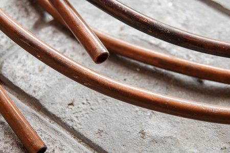 A metal copper electrical power wire cable on the brick floor.の写真素材