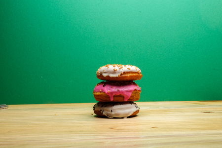 Colorful and tasty donuts on a wooden backgroundの写真素材