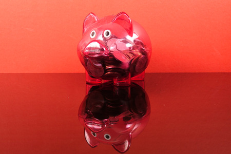 Saving concept with red piggy bank on red background.の写真素材