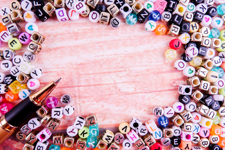 Colorful plastic alphabet dice on a wooden background as a background.の写真素材
