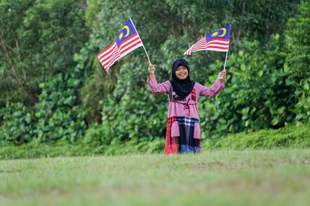 Independence Day concept -Asian kid at field holding a Malaysian flags.の写真素材