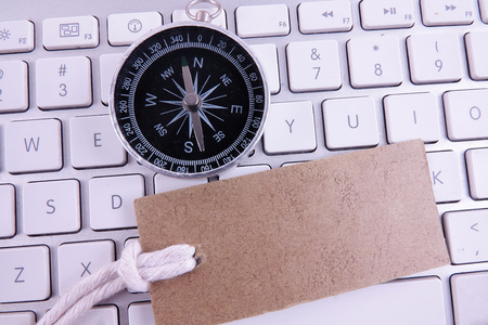 BUSINESS CONCEPT with keyboard, brown tag and compass. Copy spaceの写真素材