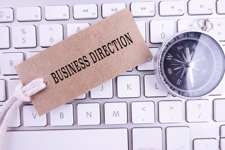 BUSINESS DIRECTION CONCEPT with keyboard, brown tag and compass.の写真素材