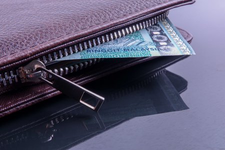 A brown men's leather wallet with reflection.