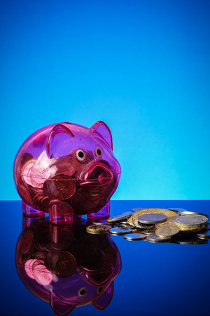 Saving concept with mason jar,coins and piggy bank on a blue background.の写真素材