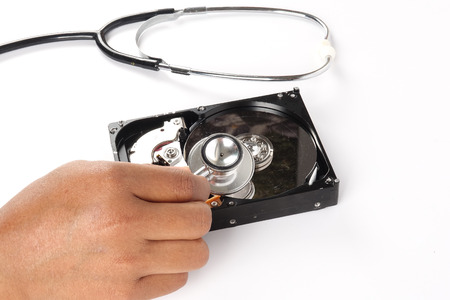 RECOVERY AND REPAIR TECHNOLOGY CONCEPT: Hard Disk Drive (HDD) with stethoscope isolated on white.