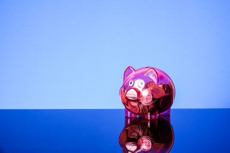 Saving concept with mason jar,coins and piggy bank on a blue background.の写真素材