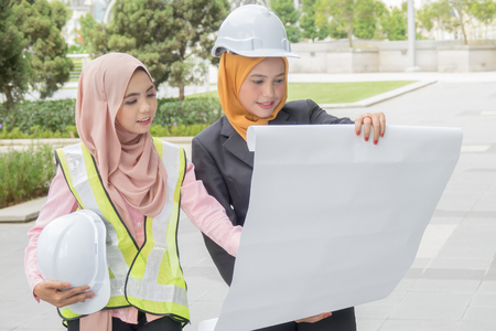 Professional woman engineers are discussing on construction at outdoor.の写真素材