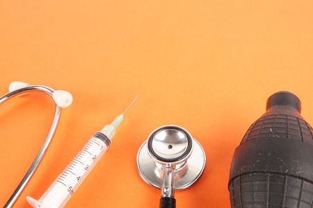 Medical Concept with stethoscope ,syringe  isolated on orange background. Copy Space