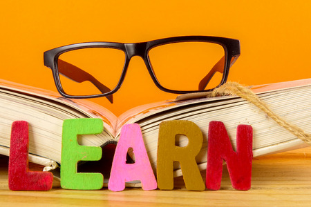 Education concept with books, alarm clock,glass with word LEARN.