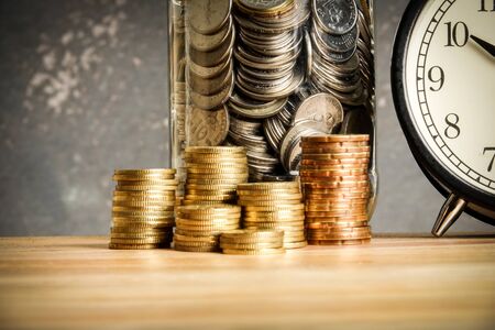 Saving concept with stack of coins on a wooden table.の写真素材