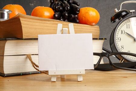 Medical concept with clock,books and stethoscope over rustic black background.の写真素材
