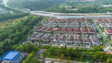 Aerial view of residential area with green asphalt road and residential houses directly above viewpoint. View of suburbs and city district. Real estate and housing market concept.の写真素材