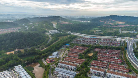 Aerial view of residential area with green asphalt road and residential houses directly above viewpoint. View of suburbs and city district. Real estate and housing market concept.の写真素材