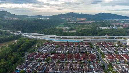 Aerial view of residential area with green asphalt road and residential houses directly above viewpoint. View of suburbs and city district. Real estate and housing market concept.の写真素材