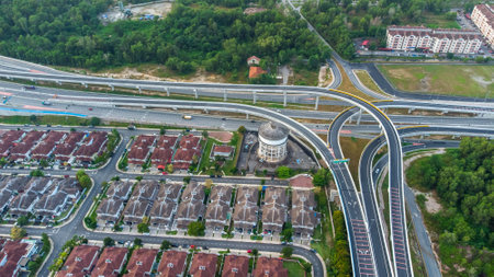 Aerial view of residential area with green asphalt road and residential houses directly above viewpoint. View of suburbs and city district. Real estate and housing market concept.の写真素材