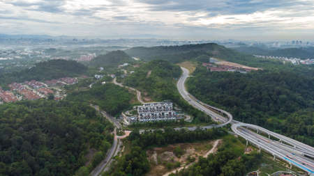 Aerial view of residential area with green asphalt road and residential houses directly above viewpoint. View of suburbs and city district. Real estate and housing market concept.の写真素材