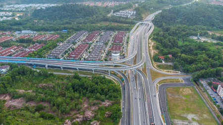 Aerial view of residential area with green asphalt road and residential houses directly above viewpoint. View of suburbs and city district. Real estate and housing market concept.の写真素材