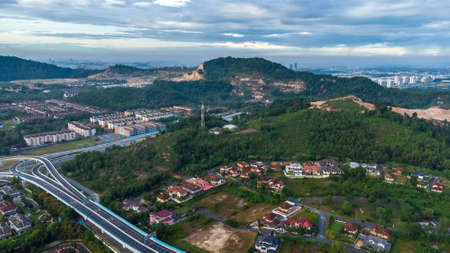 Aerial view of residential area with green asphalt road and residential houses directly above...