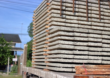 Close up side view of truck while load stack of prestressed concrete slabs for constructionの写真素材