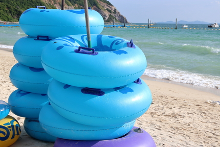 Stack of blue floating rings on the coastline,swim ring, rubber ring, swimming tubesの写真素材