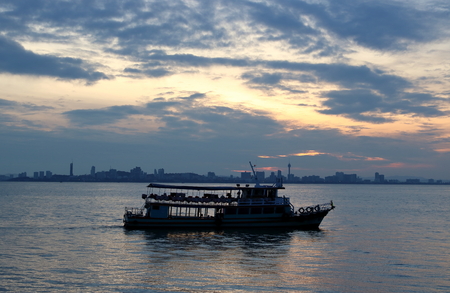 Silhouette of a passenger ferry boat during sunriseの写真素材