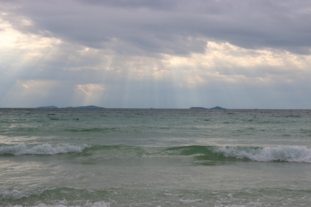 Sun beam through heavy sky before a powerful storm , view from seashoreの写真素材