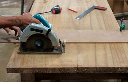 Circular saw cutting piece of wood in carpentry workshopの写真素材