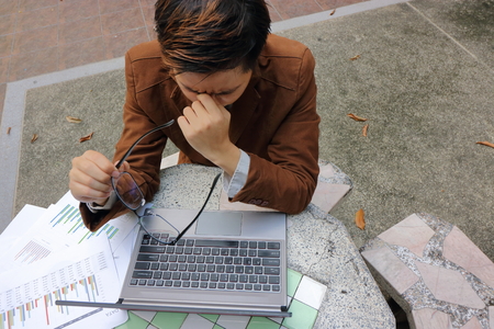 Business man takes off glasses and close his eyes. he is feeling strain or tried and headache.の写真素材